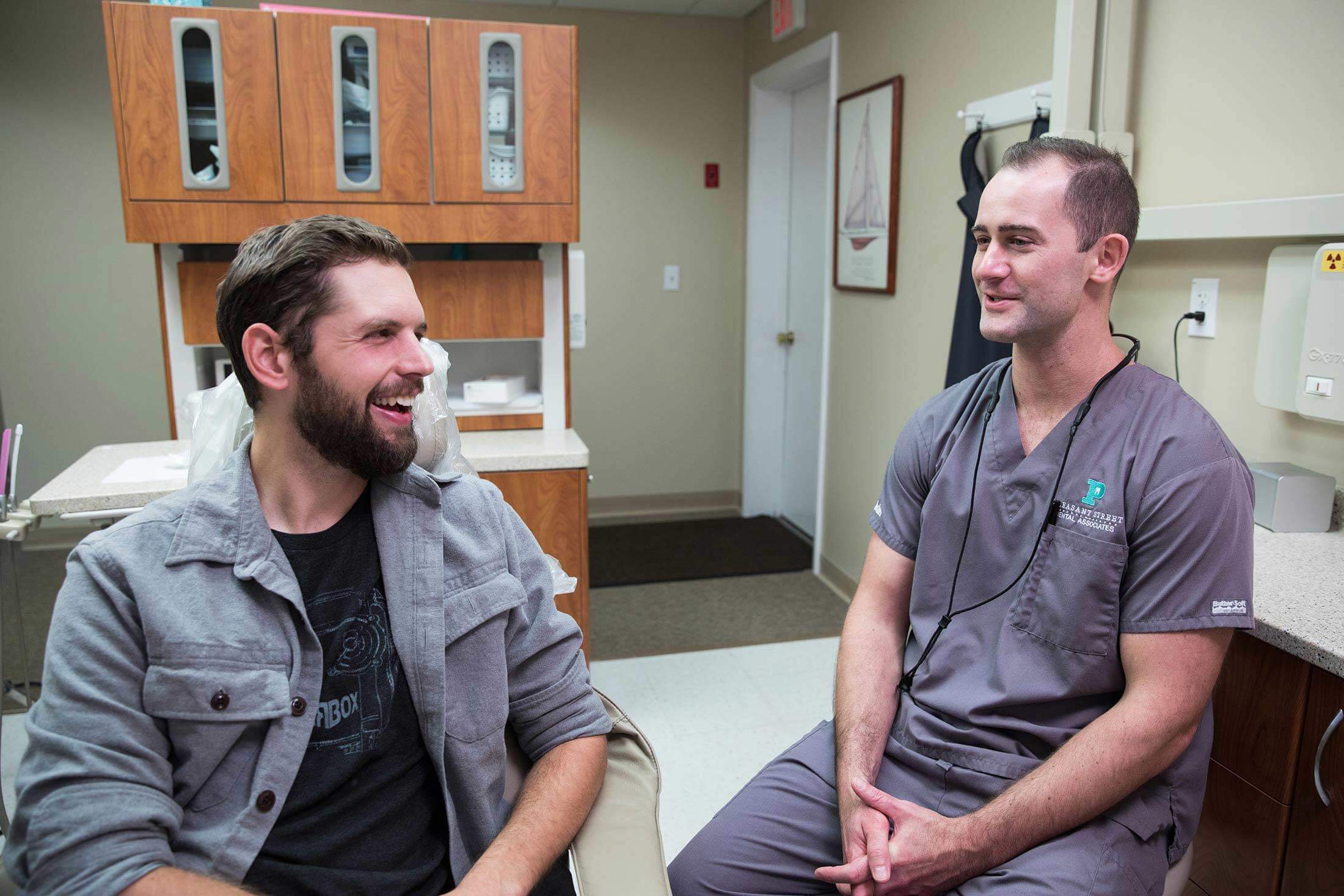 Dentist Dr James Moshier talks with a smiling patient
