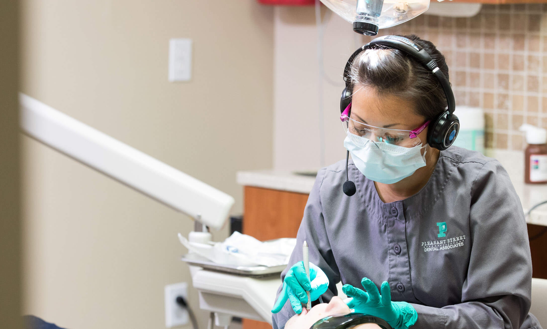 female dental hygienist cleaning a patient's teeth